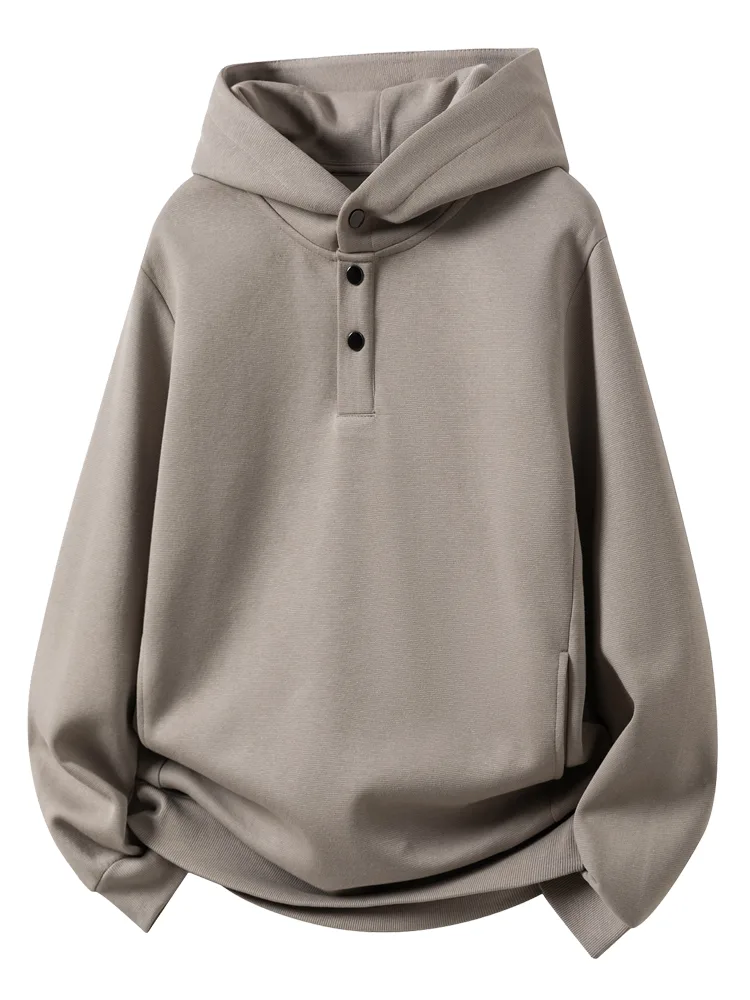 A khaki hooded sweatshirt with a half-button placket, packed and ready alongside other styles for one booking